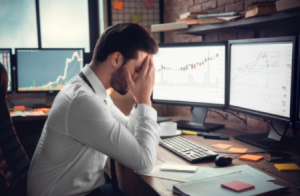 forex trader with head in hands in despair